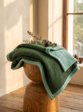 Creative Home's Green waffle and muslin organic cotton blanket layered on wooden bench, breathable 8-layer reversible luxury throw blanket,BB-DesH-WaMusBlnkt-Grn-6070,BB-DesH-WaMusBlnkt-Grn-Tw,BB-DesH-WaMusBlnkt-Grn-Q,BB-DesH-WaMusBlnkt-Grn-K,BB-DesH-WaMusBlnkt-Grn-100118,BB-DesH-WaMusBlnkt-Grn-100125