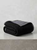 Creative Home's Black waffle weave organic cotton blanket with soft muslin backing styled on rustic wooden bench near fireplace, luxury reversible throw,BB-DesH-WaMusBlnkt-Bla-6070,BB-DesH-WaMusBlnkt-Bla-Tw,BB-DesH-WaMusBlnkt-Bla-Q,BB-DesH-WaMusBlnkt-Bla-K,BB-DesH-WaMusBlnkt-Bla-100118,BB-DesH-WaMusBlnkt-Bla-100125